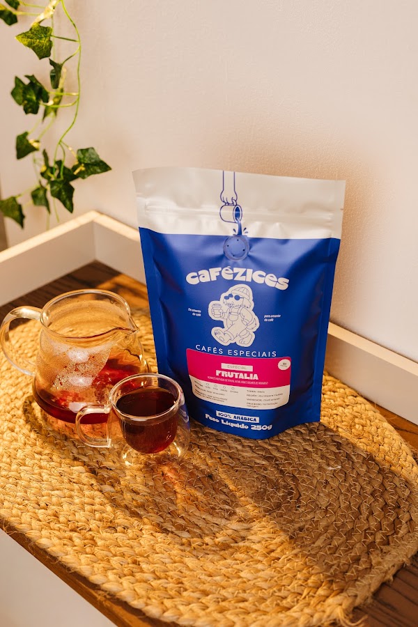 Pacote do caf&eacute; especial Frut&aacute;lia com bule de vidro e x&iacute;cara de caf&eacute; na luz do sol