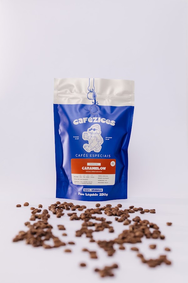 Pacote do caf&eacute; Caramelow em fundo branco com gr&atilde;os espalhados