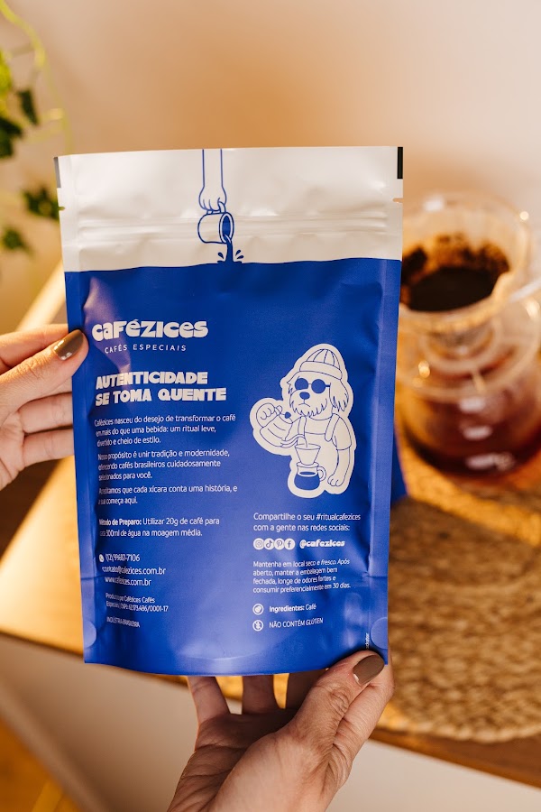 M&atilde;o mostrando o verso de um pacote de caf&eacute; da Caf&eacute;zices com as informa&ccedil;&otilde;es do caf&eacute;